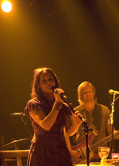 Sophie Zelmani en concert, avec son bassiste en arrière-plan.
