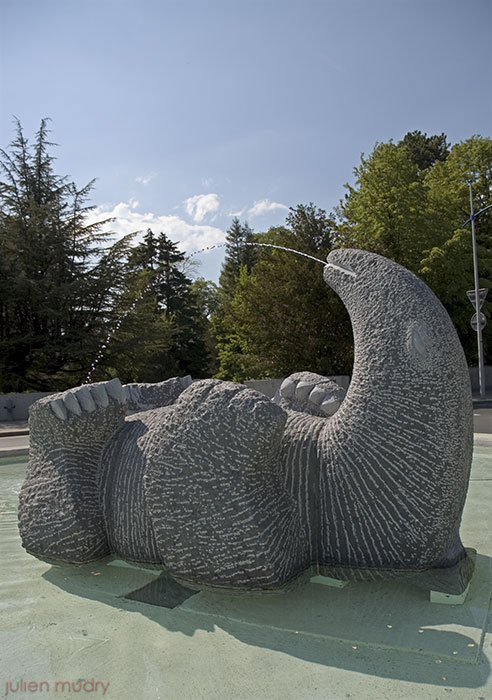 Une sculpture d'un monstre heureux couché sur le dos dans l'eau.