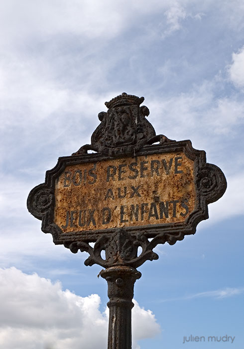 Un panneau rouillé indiquant "Bois réservé aux jeux d'enfants".